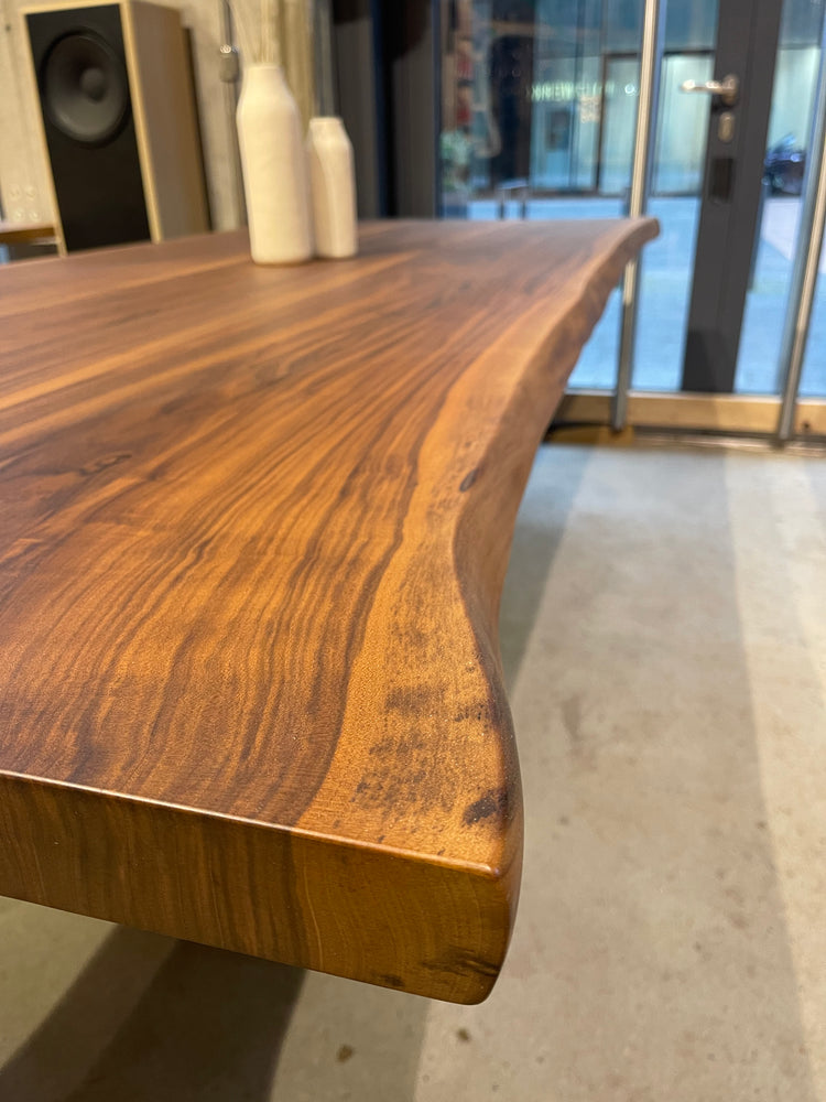 Stylischer Esstisch aus Nussbaum mit Tischgestell aus Beton in Wangenform